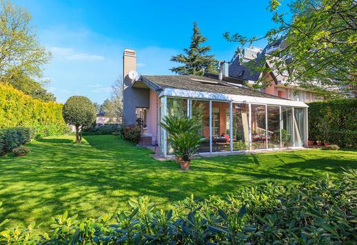 Élégante résidence de 427 m² sur trois niveaux, avec une véranda vitrée habitable toute l'année, un sous-sol aménagé et un jardin privé d'environ 400 m², à quelques pas du cœur de la vie milanaise Image 1